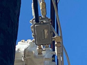 Aerial amplifier housing and connectors against a clear sky