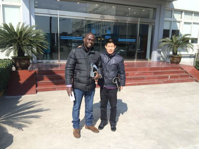 Outside the factory main entrance with a colleague during the supplier visit