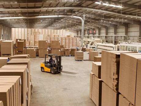 Warehouse interior at the packaging plant with industrial high-bay lighting